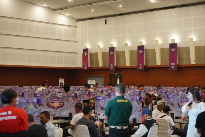 
					Peserta mengikuti pertandingan dalam Surabaya Domino Tournament 2026 di Grand City Convention Hall dengan ratusan meja permainan yang terisi dan suasana kompetisi yang ramai.