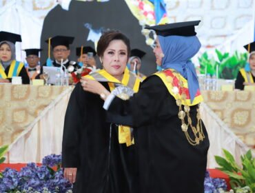 Rektor Unitomo, Prof. Dr. Siti Marwiyah, memindahkan kuncir toga Prof. Dr. Ully Tampubolon saat prosesi Pengukuhan Guru Besar di Kampus Universitas Dr. Soetomo, Surabaya. (21/05/2026). (SAN)