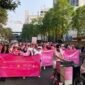 Peserta NCO Pink Morning Club membawa spanduk saat fun walk Pink October di Surabaya.